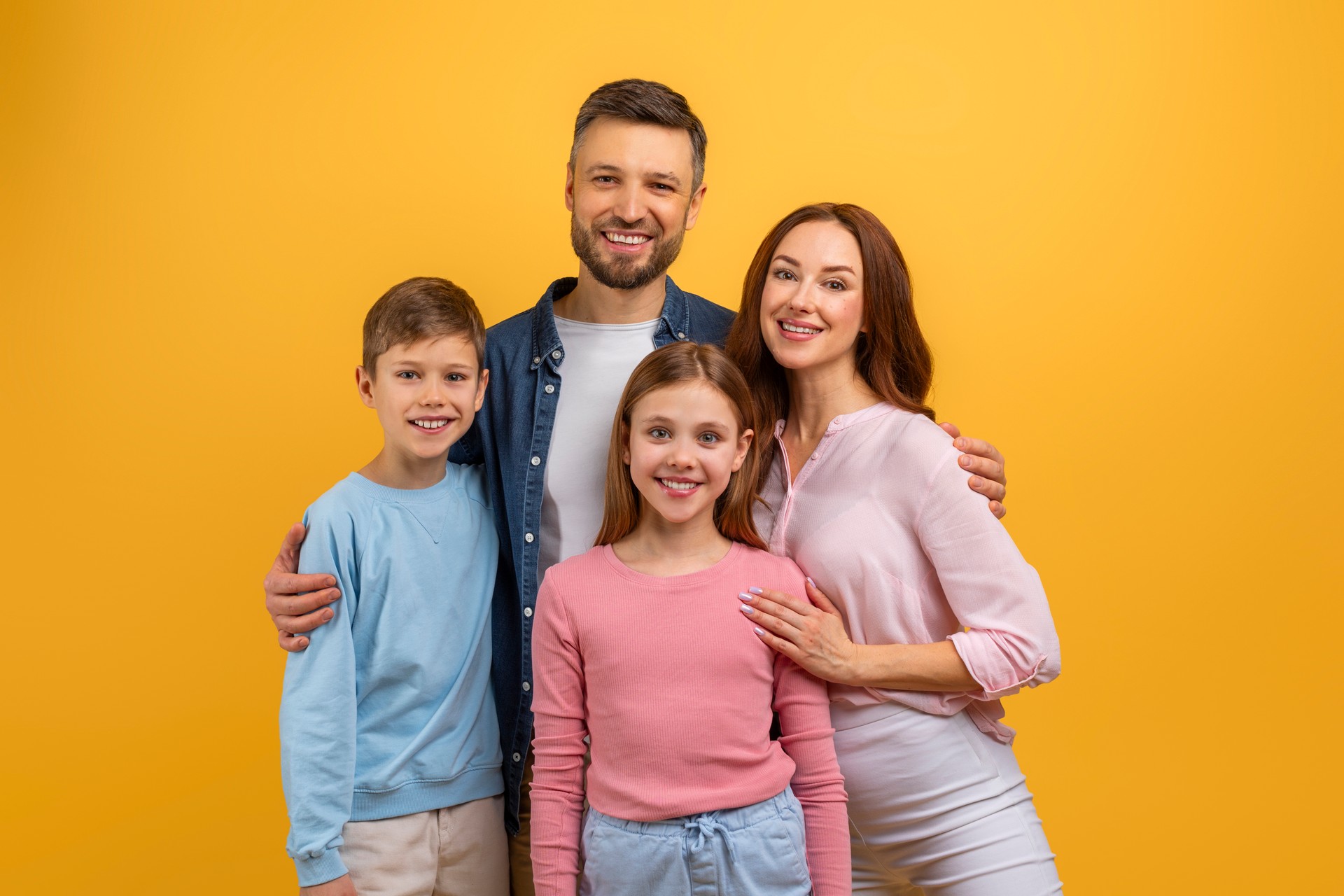 Family Posing for a Picture in Front of Yellow Background