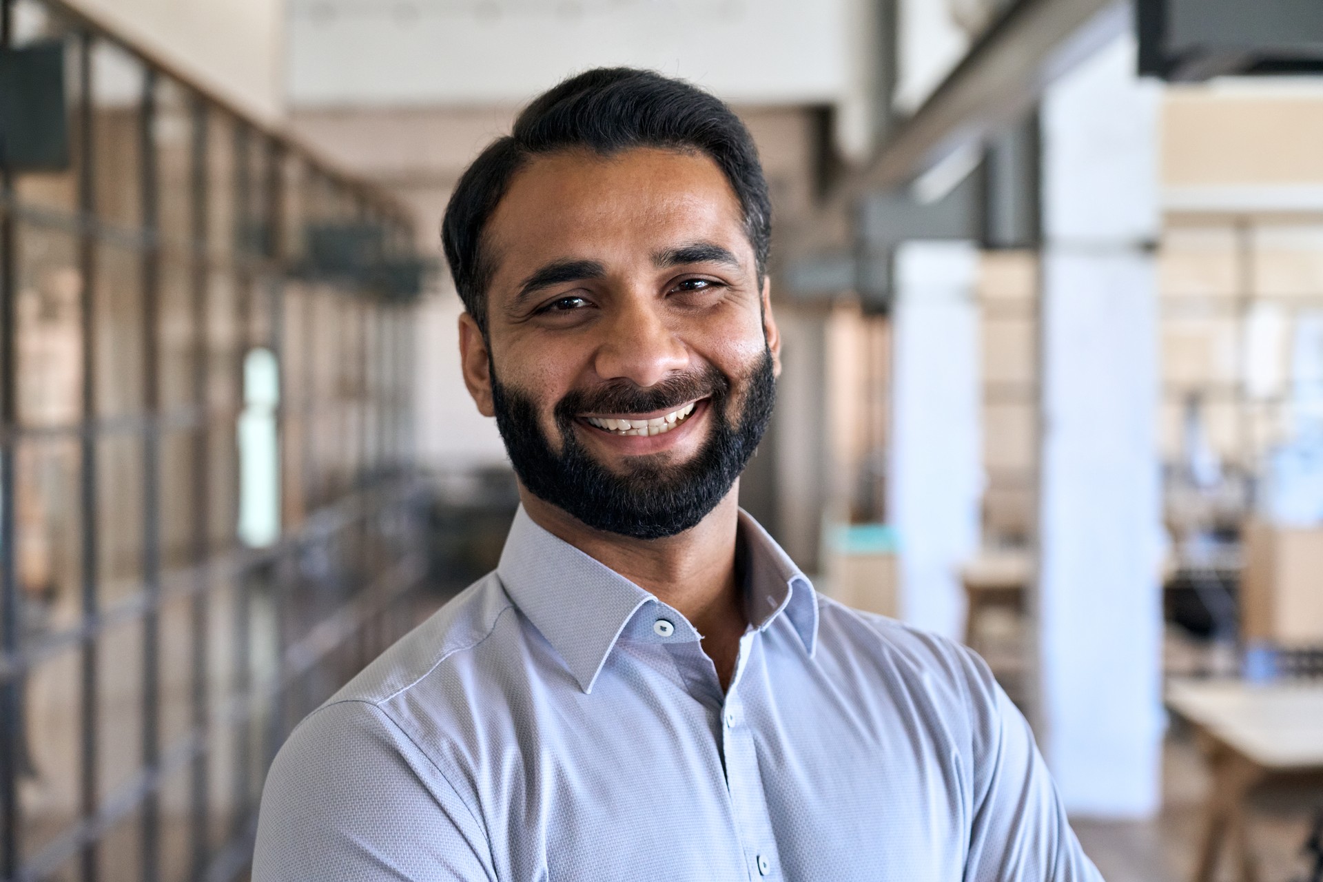 Happy indian business man leader manager standing in office, headshot portrait.